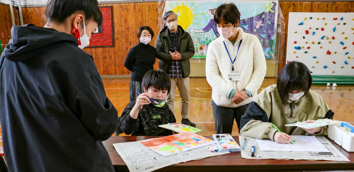 蟹江さん(左)と作品制作に取り組む児童生徒