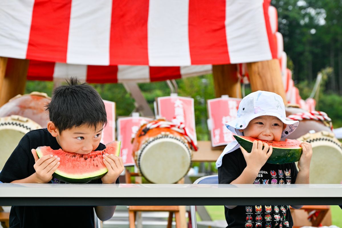 早食い大会でスイカを頬張る子どもたち