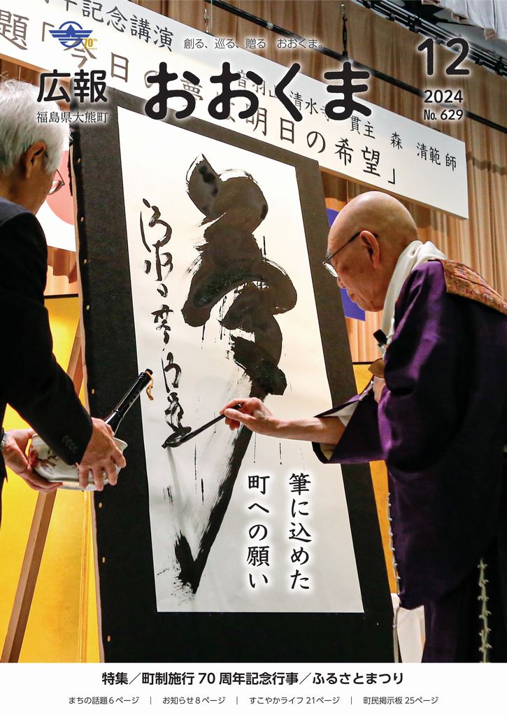 大熊町町制施行70周年記念講演で揮毫する音羽山清水寺貫主、森清範師（右）