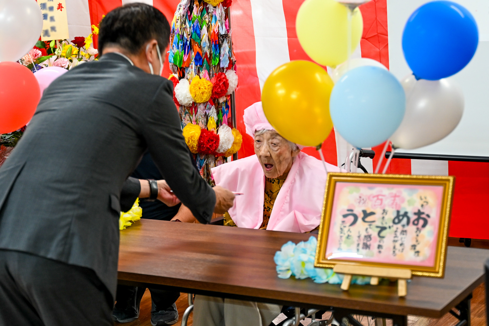 吉岡副町長から祝金を受け取る金子さん（右）
