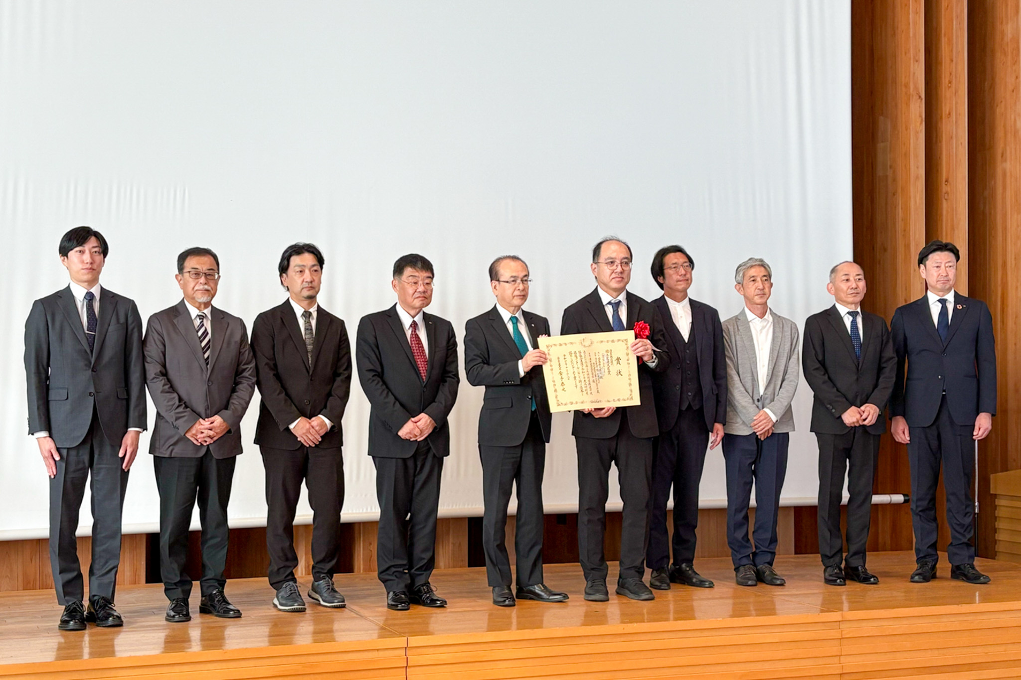 記念撮影に納まった吉田町長（左から5人目）と設計・施工業者ら