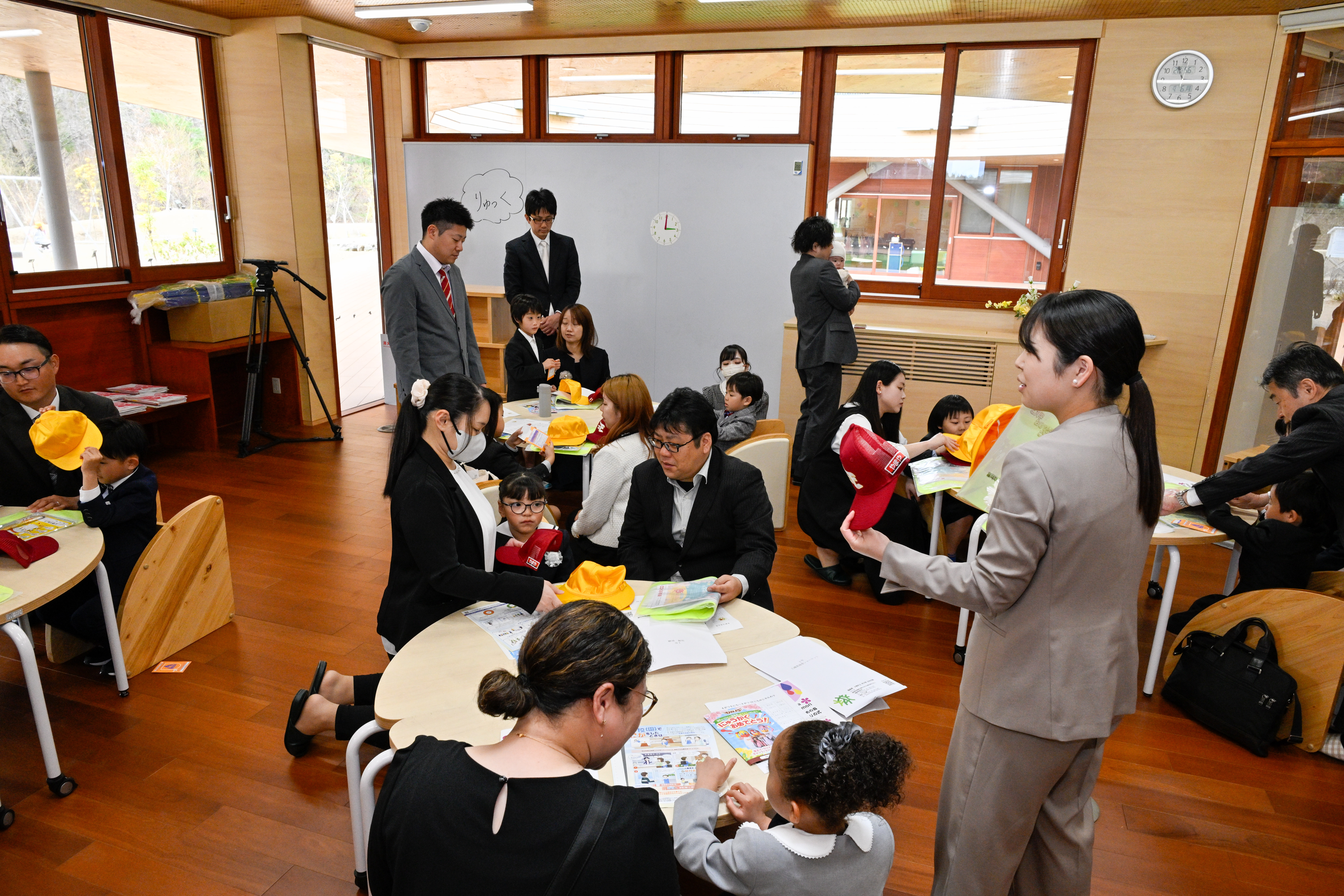 入学にあたり、学校の説明を受けた児童と保護者ら